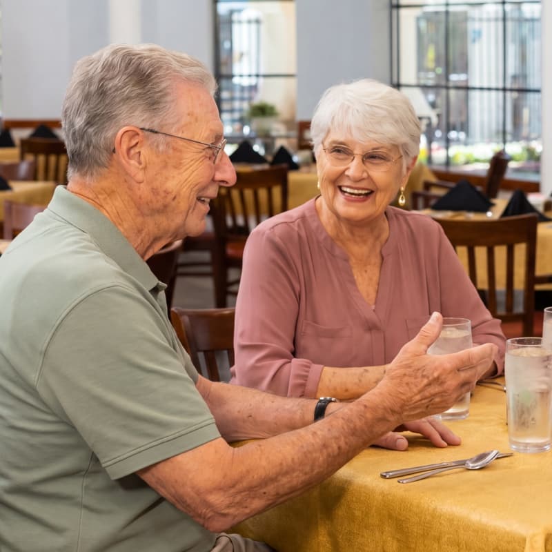 Senior man and woman in dining room talking at Fellowship Square Mesa Independent Living community