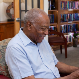 Senior man sitting in the library at Fellowship Square Independent Living community