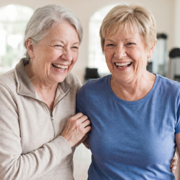 Two senior women smiling and laughing together in the Fitness Center at Fellowship Square Independent Living community